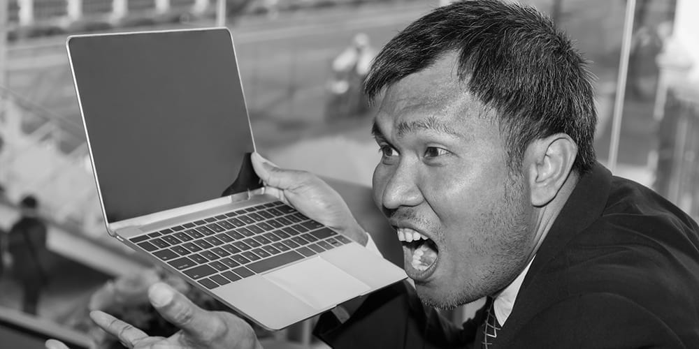 Angry man holding his laptop